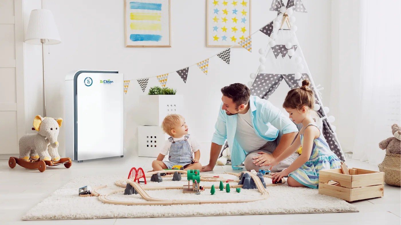 Father and children playing with a toy train next to a Dr.Clean air purifier